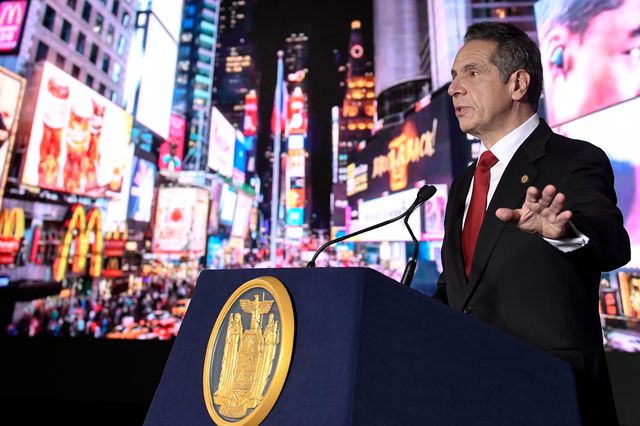 Governor Andrew Cuomo stands in front of an image of Times Square during his annual state of the state address.